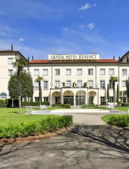 Elegant hotel with garden, fountain, and restaurant.