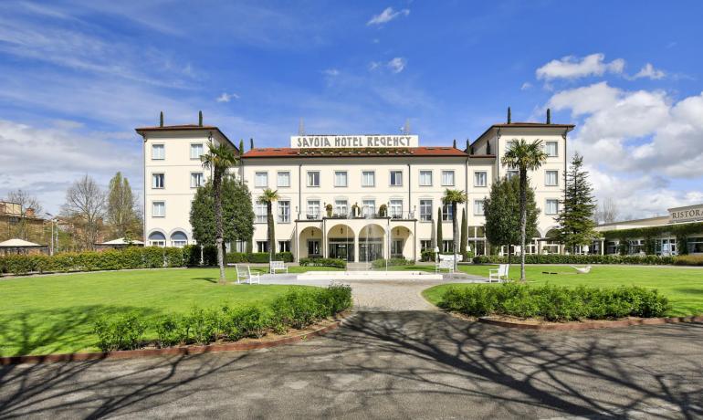 Elegante hotel con giardino, fontana e ristorante.