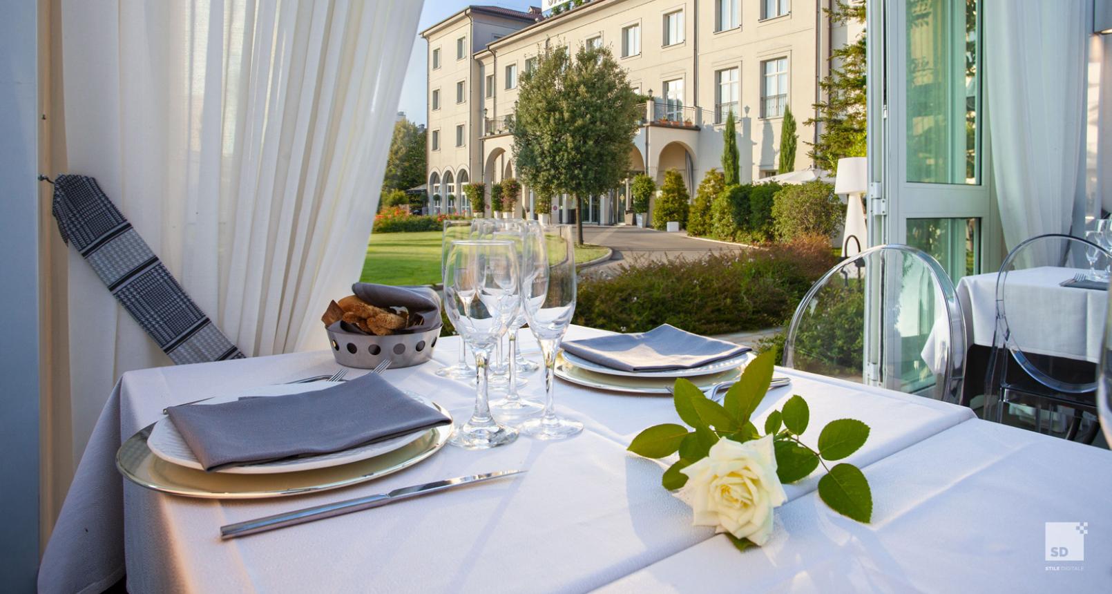 Tavolo apparecchiato con vista sul giardino del Savoia Hotel Regency.