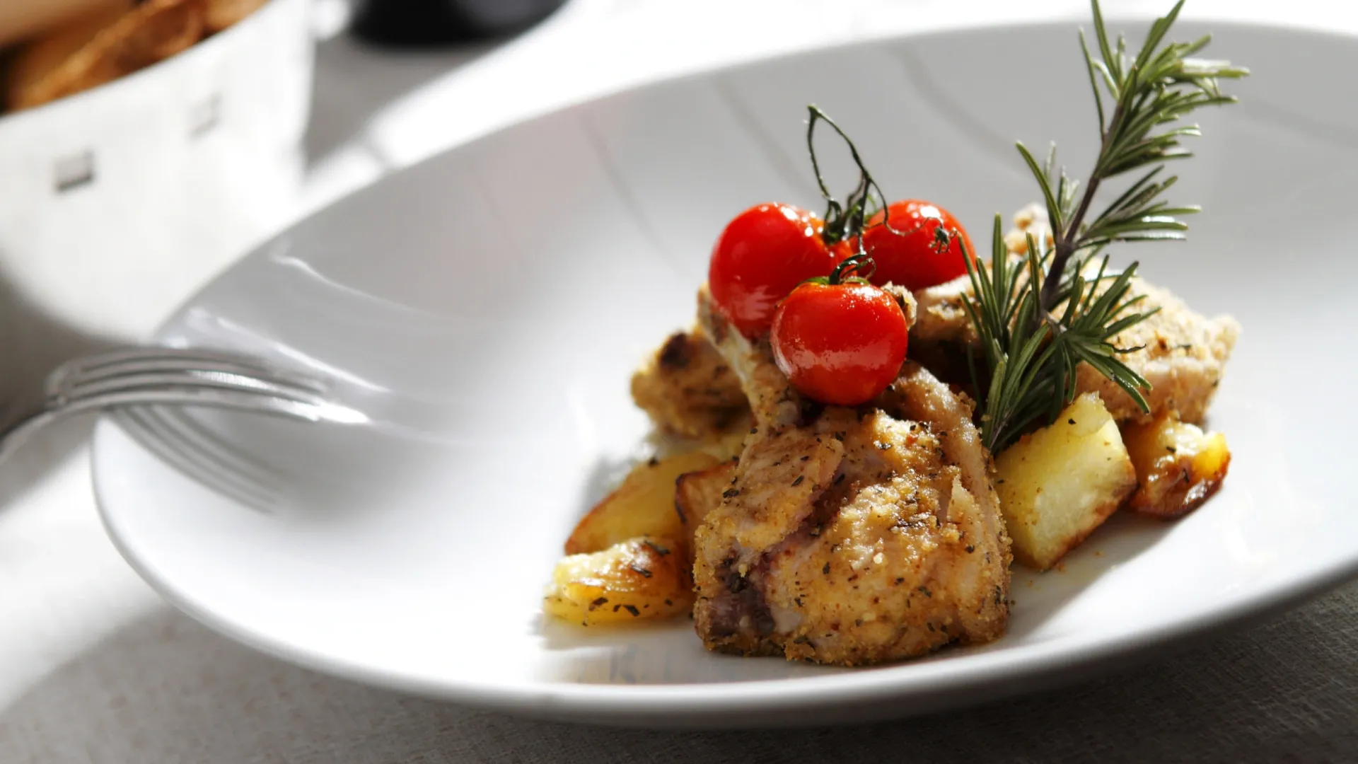 Chicken dish with potatoes, cherry tomatoes, and rosemary.
