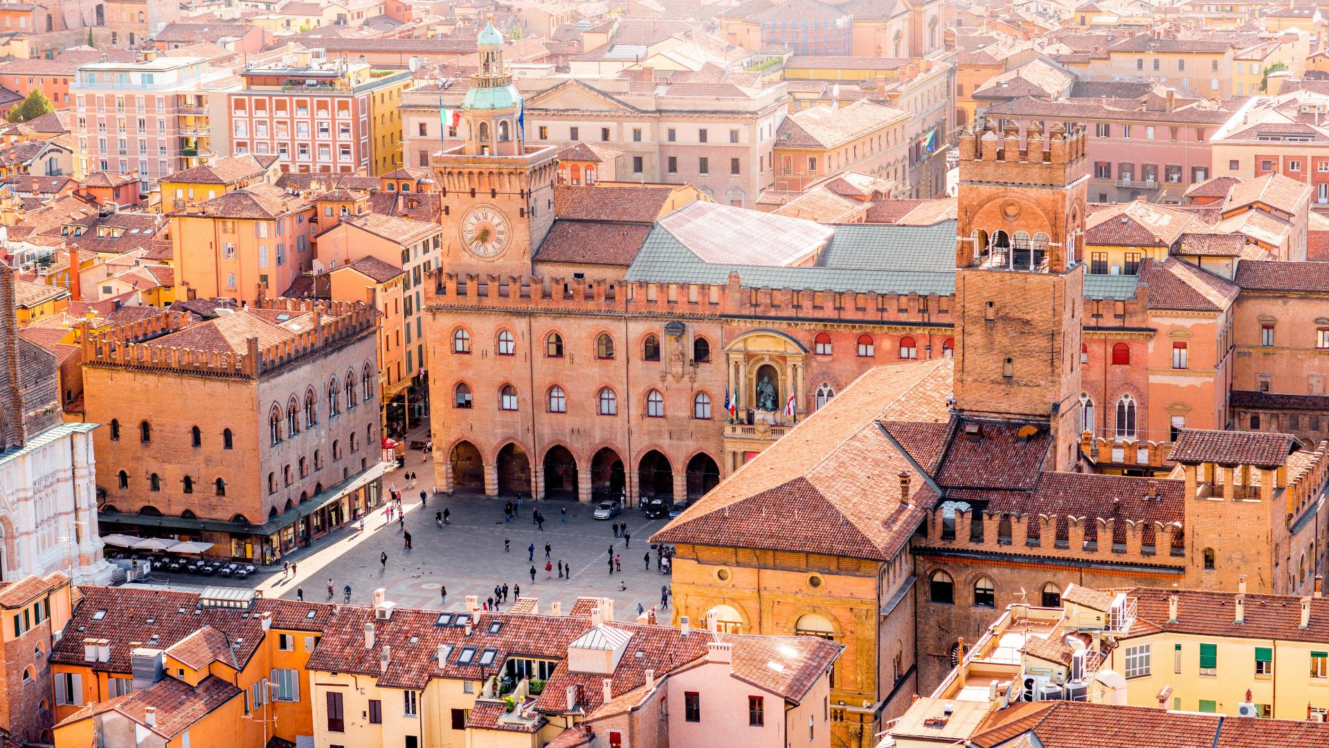 Piazza Maggiore a Bologna con storici edifici medievali e la Torre dell'Orologio.