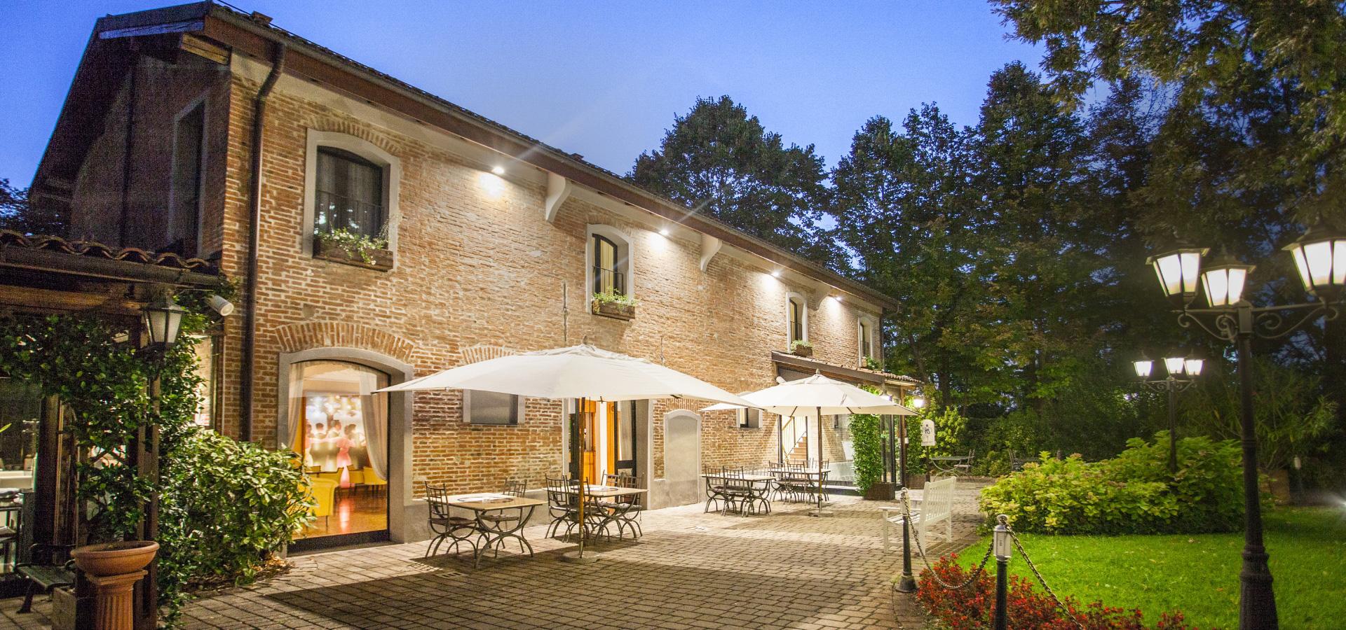 Accogliente terrazza di un ristorante con tavoli all'aperto e illuminazione serale.