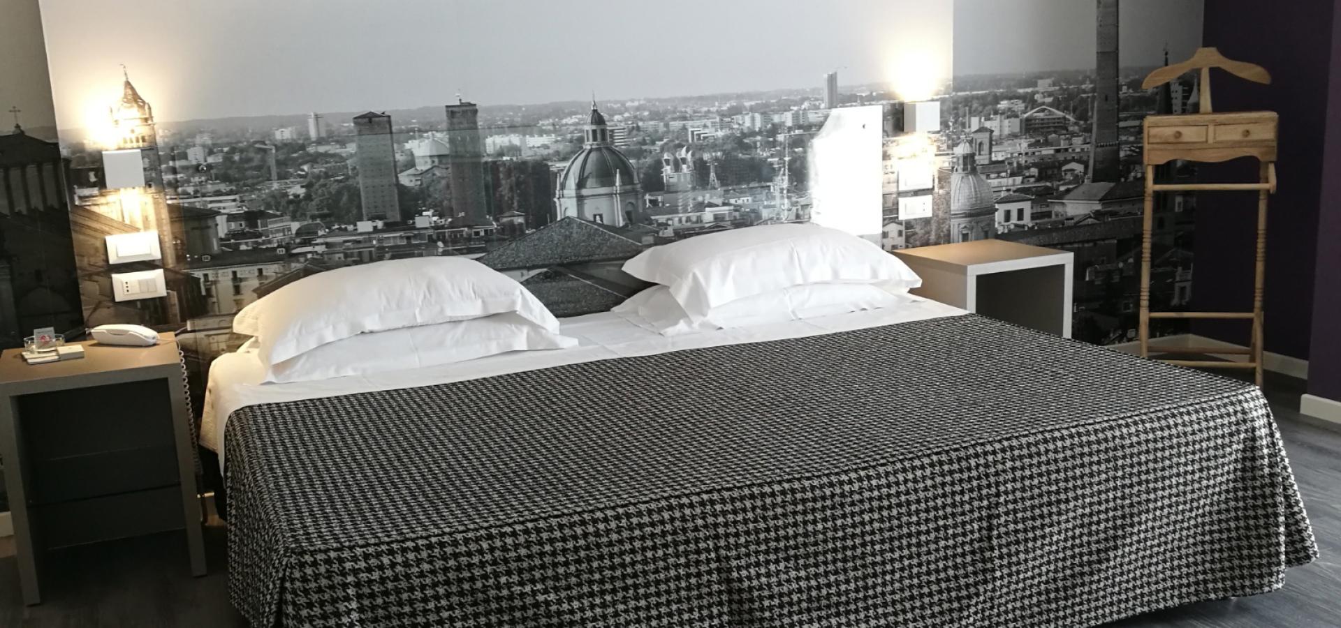 Modern room with double bed, decorated wall, and nightstands.