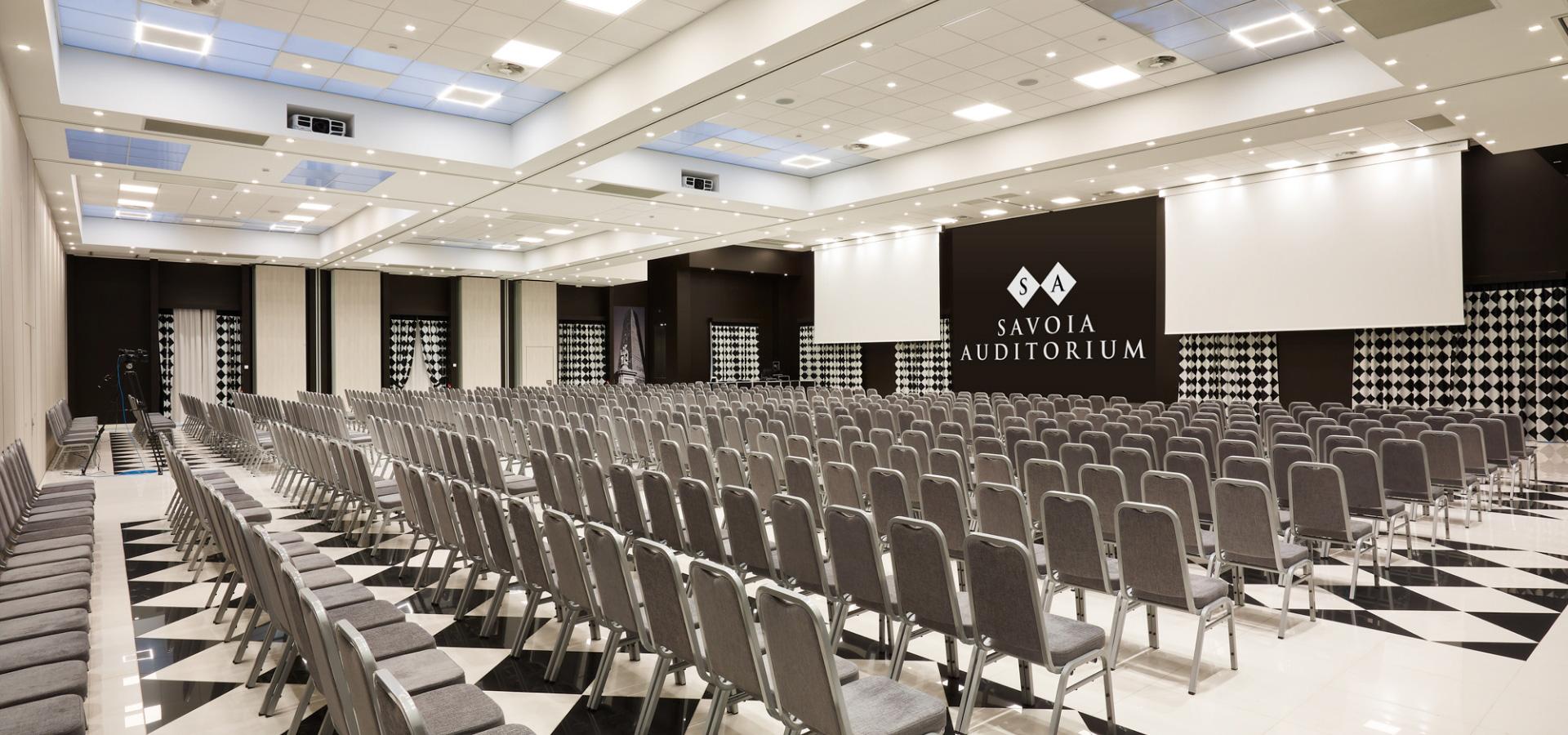 Ampio auditorium con molte sedie, ideale per conferenze ed eventi.