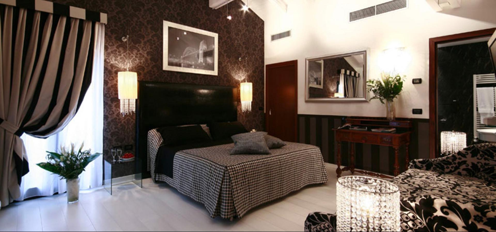 Elegant room with double bed, hanging lamps, and black-and-white decor.