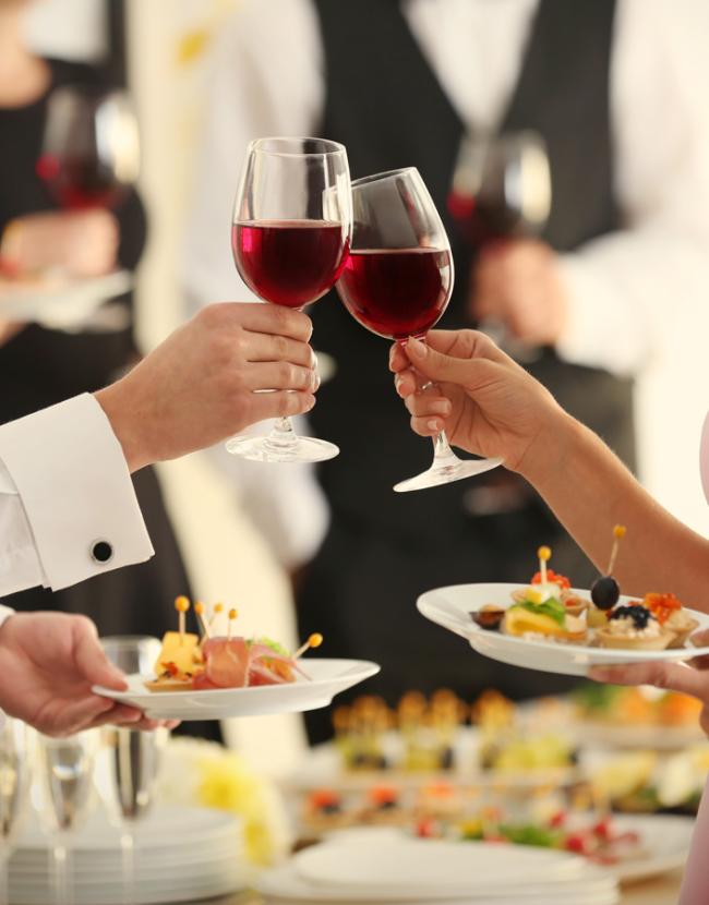 Due persone brindano con vino rosso durante un evento elegante.