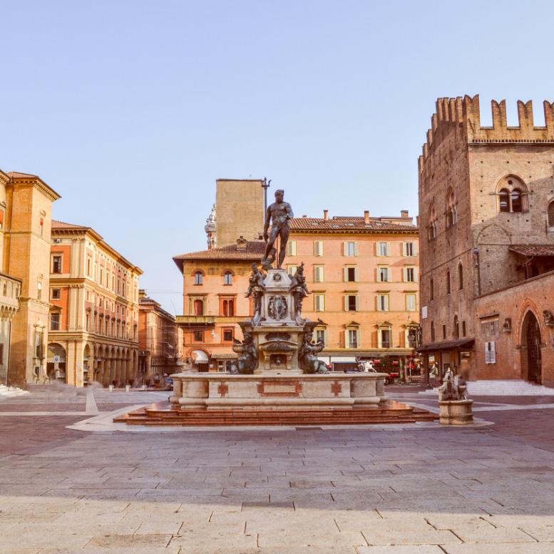 Fontana del Nettuno a Bologna, circondata da edifici storici.