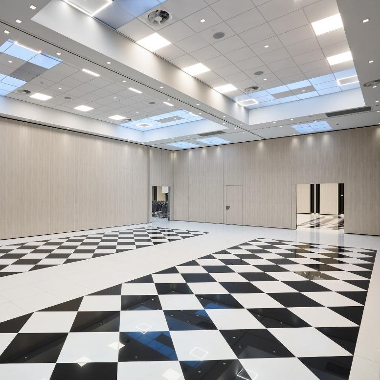 Sala moderna con pavimento a scacchi e soffitto con lucernari.