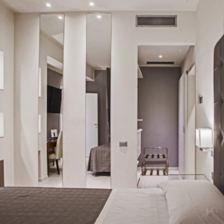 Modern room with a double bed and wall mirrors.