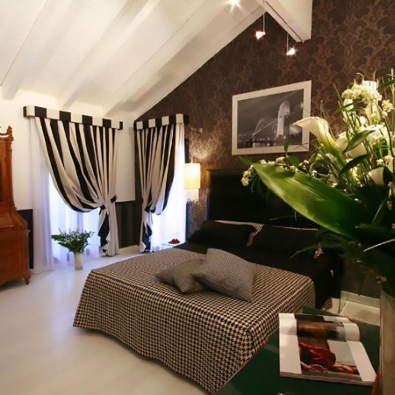 Elegant bedroom with checkered bed and black and white striped curtains.