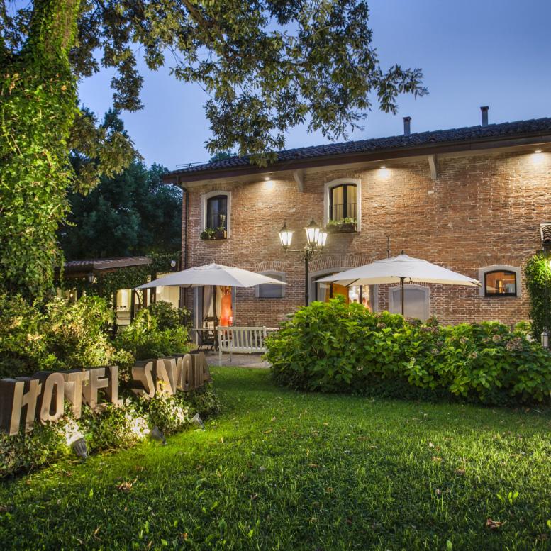 Rustic hotel with a well-kept garden and enchanting evening lighting.