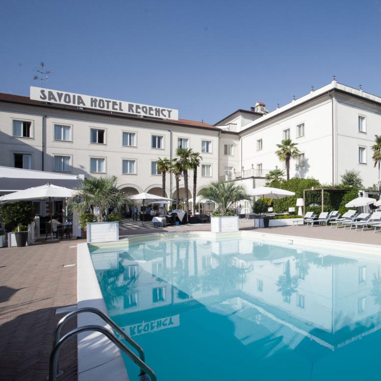 Elegant hotel with pool and palm trees, perfect for a relaxing stay.