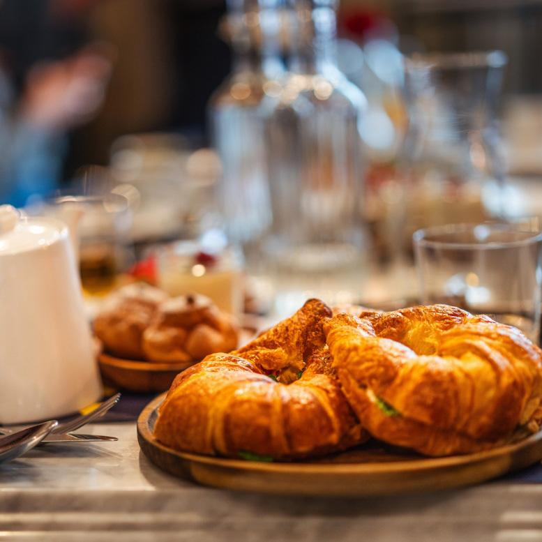 Croissants on a set table with dishes and glasses.