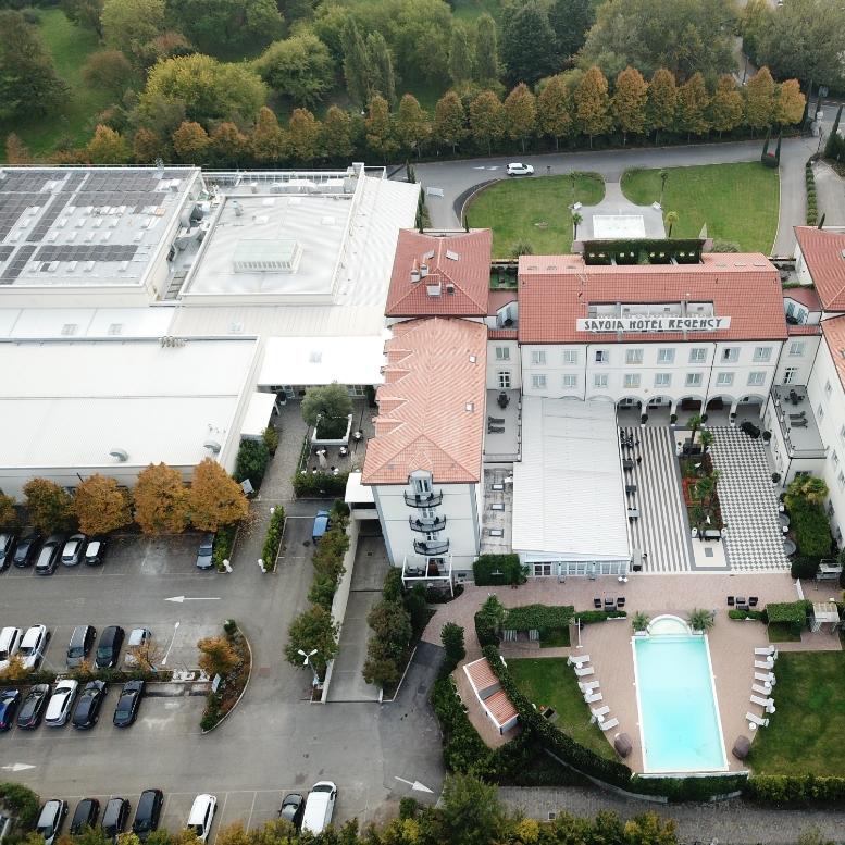 Aerial view of Savoia Hotel Regency with pool and parking area.