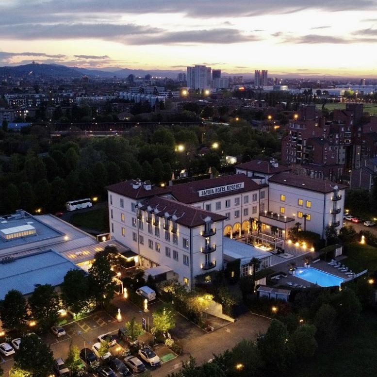 Hotel elegante con piscina, vista città al tramonto.